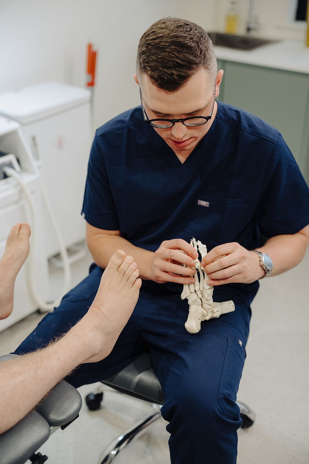 Podiatrist examining the ball of a patient's foot at Assure Health in Carryduff, Belfast