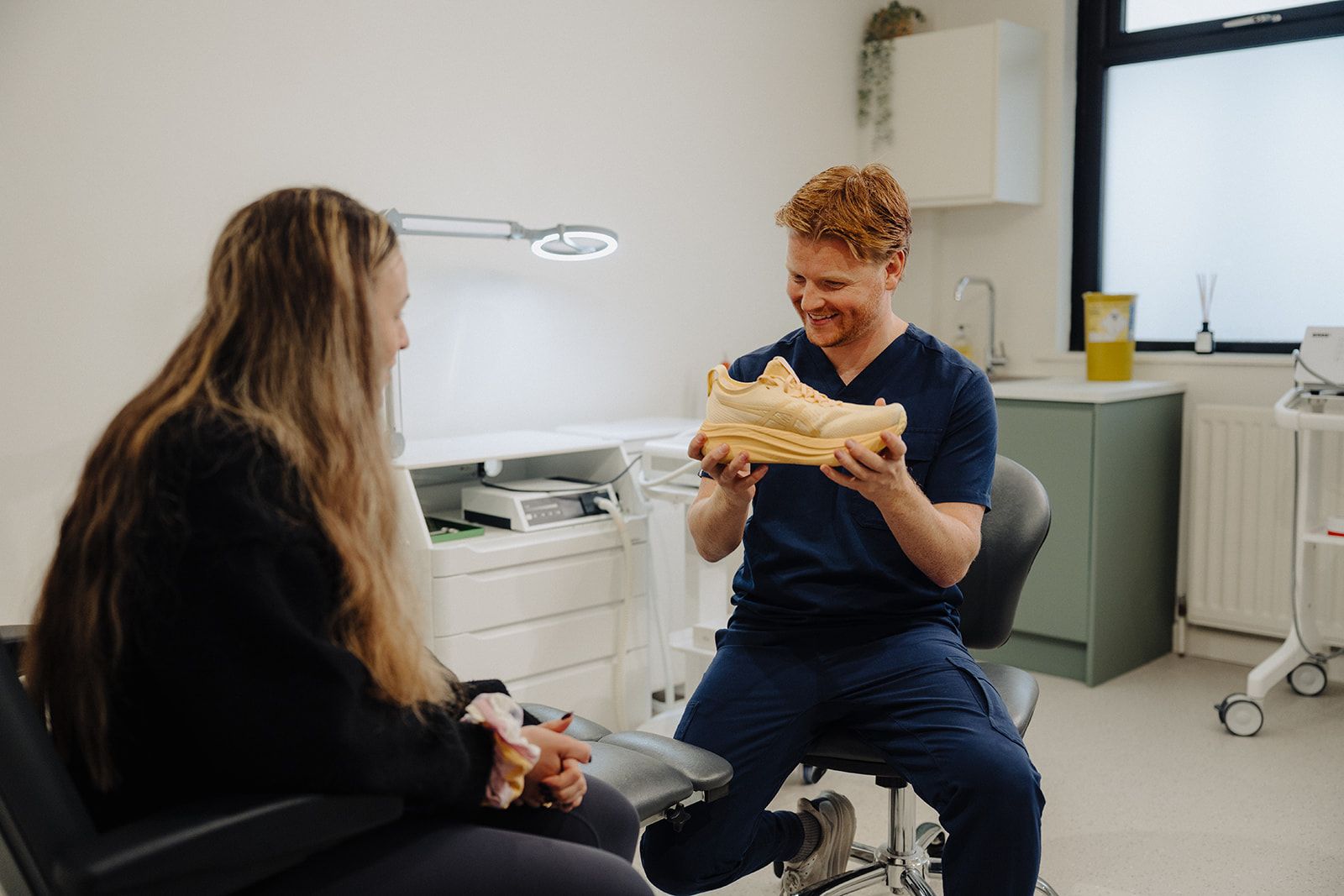 Podiatrist examining a bunion at the base of a patient's big toe at Assure Health in Carryduff, Belfast