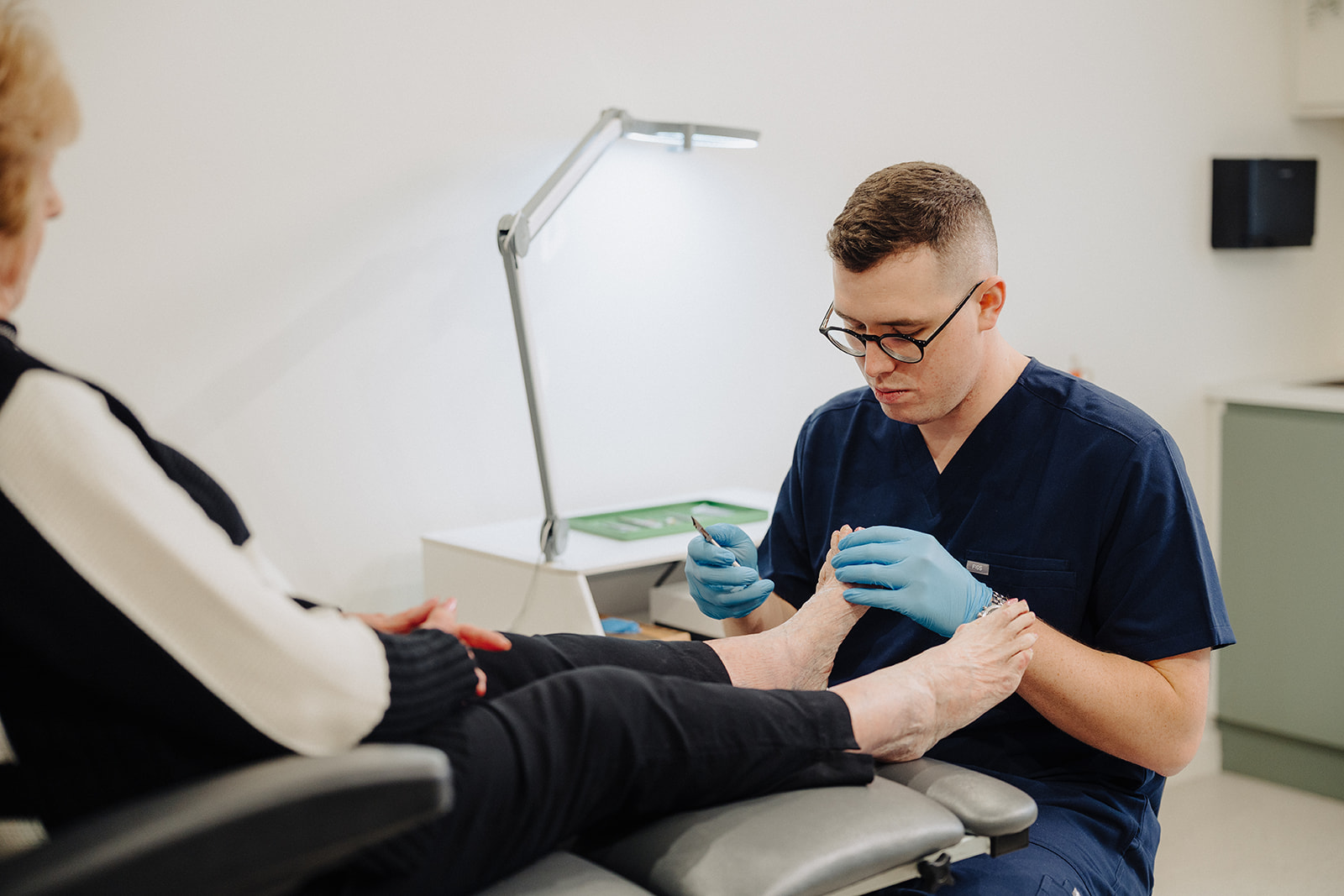 HCPC registered podiatrist treating a patient at Assure Health clinic in Carryduff, Belfast