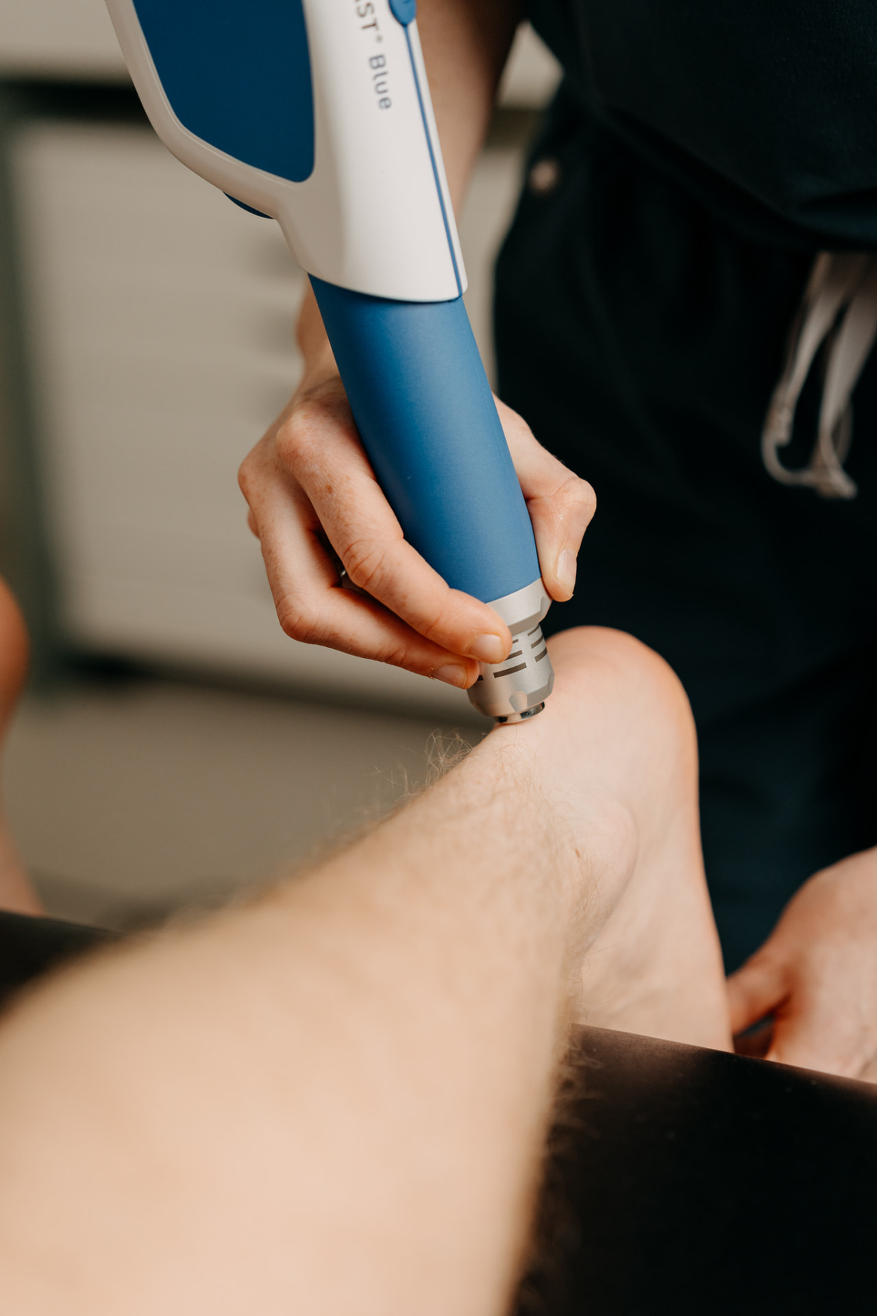 Physiotherapist assessing a runner's Achilles tendon at Assure Health in Carryduff, Belfast