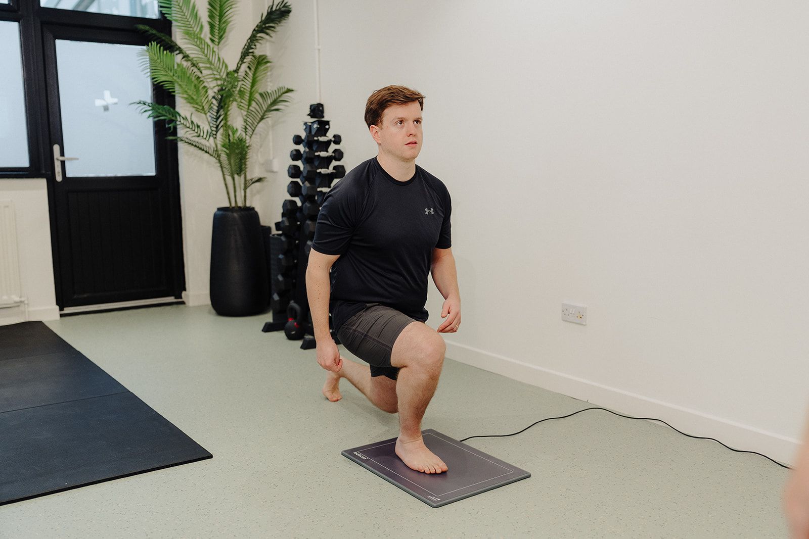 Physiotherapist assessing a runner's knee at Assure Health in Carryduff, Belfast