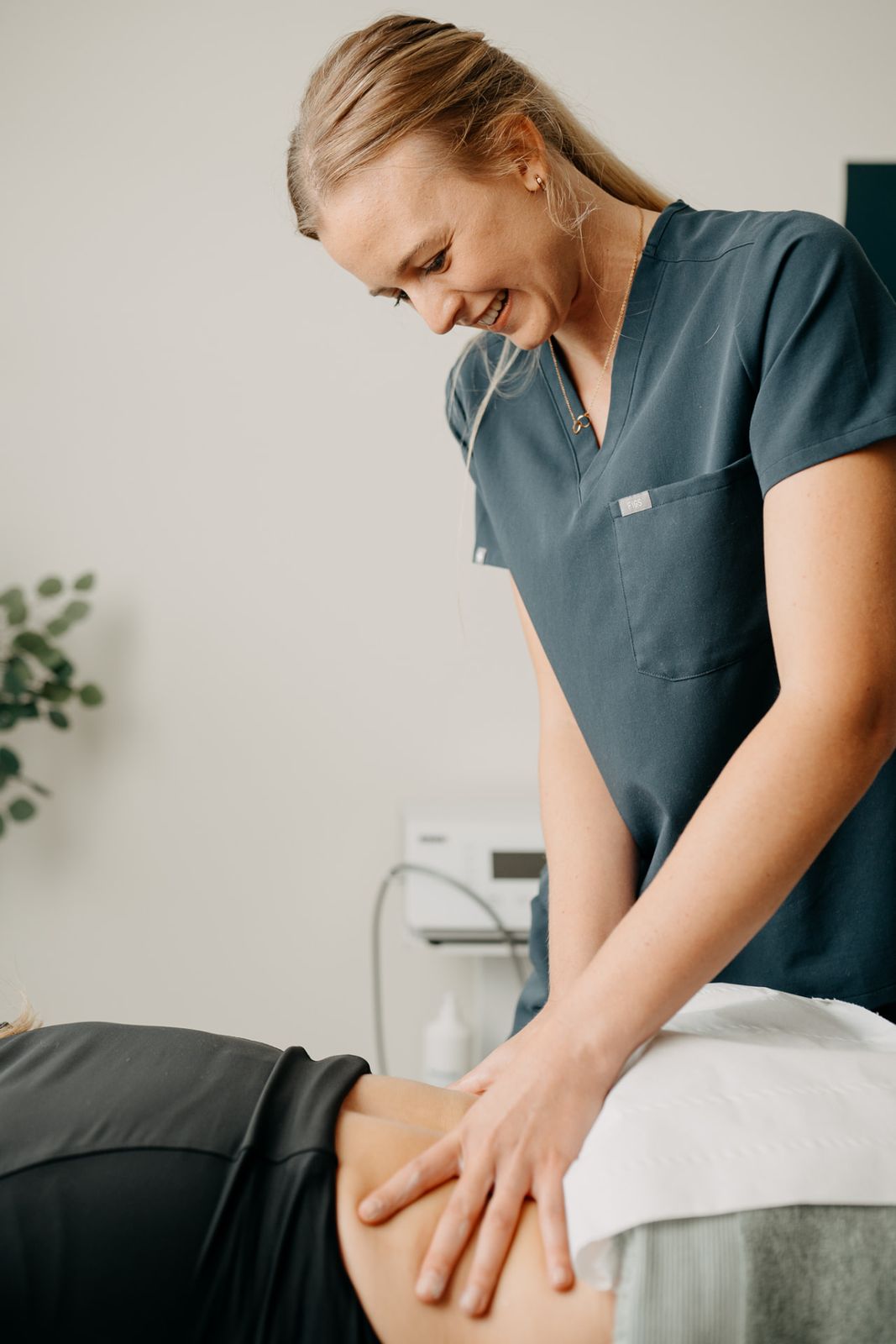 Physiotherapist treating a patient's lower back at Assure Health in Carryduff, Belfast