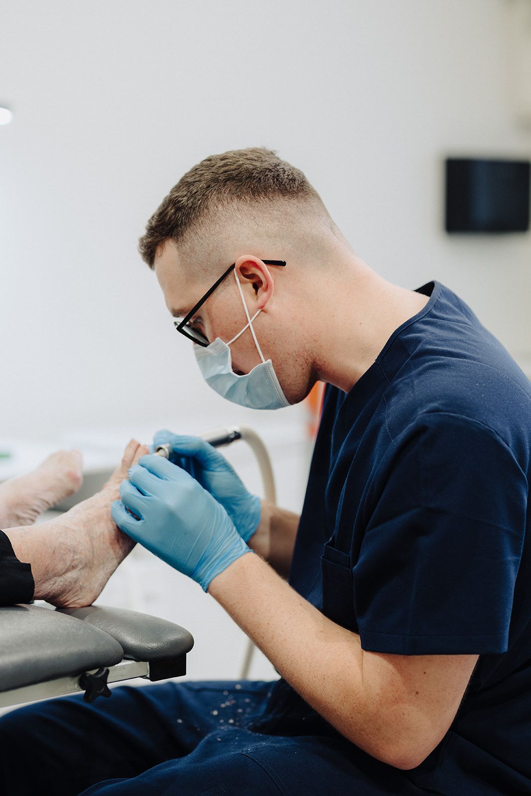 Podiatrist treating a patient's fungal toenail at Assure Health in Carryduff, Belfast