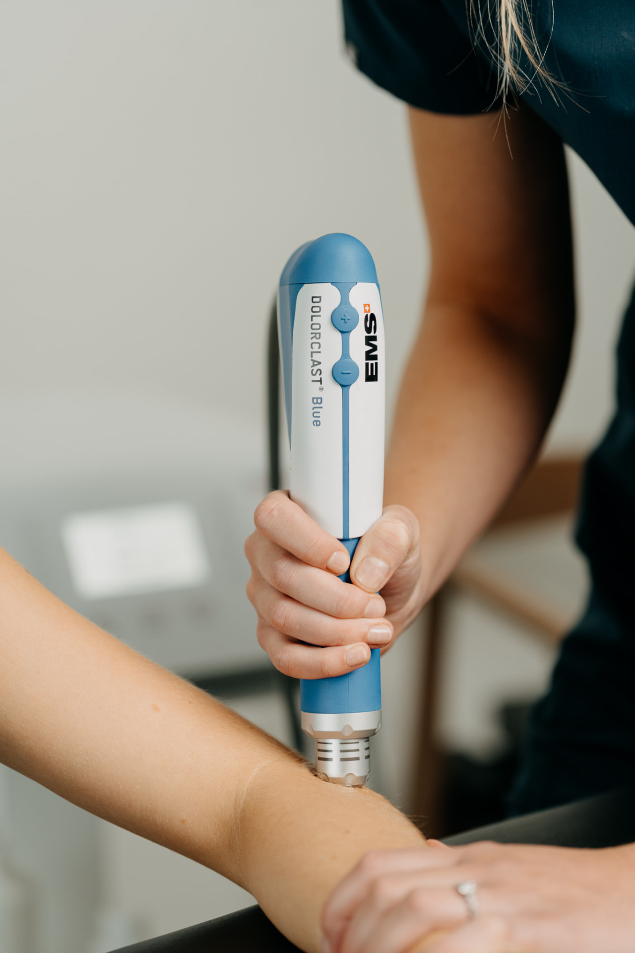 EMS shockwave device used on a patient's forearm tendon at Assure Health in Carryduff, Belfast