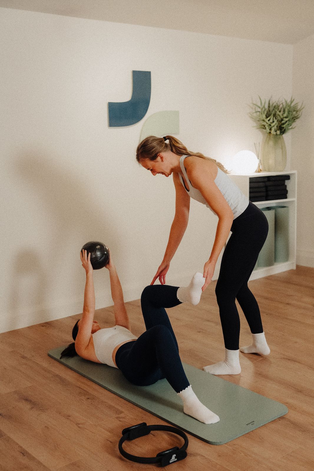 Clinical Pilates instructor guiding a client through an exercise at Assure Health, Carryduff