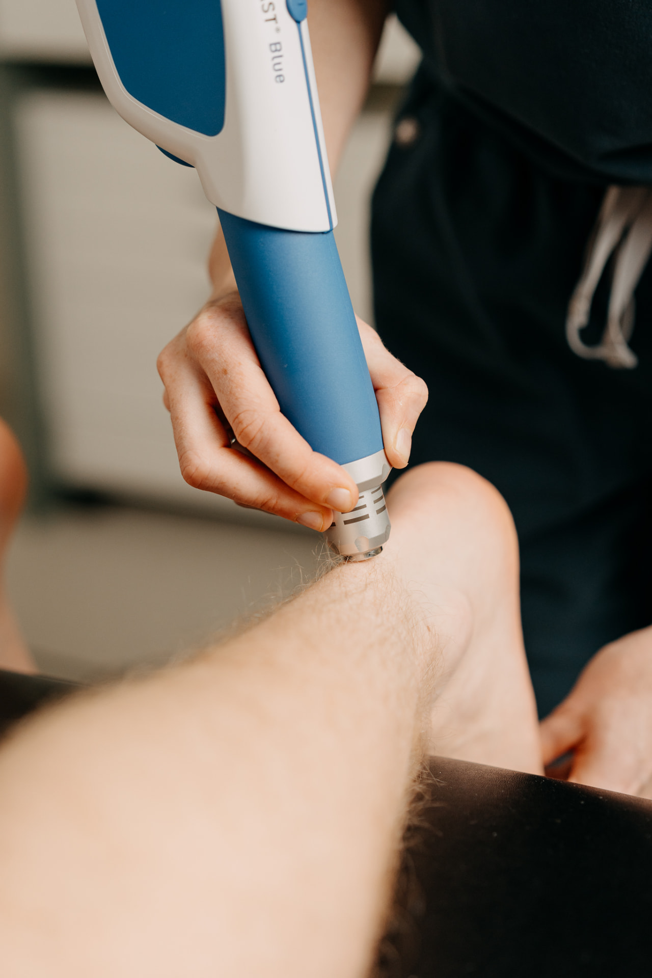 Shockwave therapy applied to the lower leg for Achilles tendinopathy at Assure Health in Carryduff, Belfast